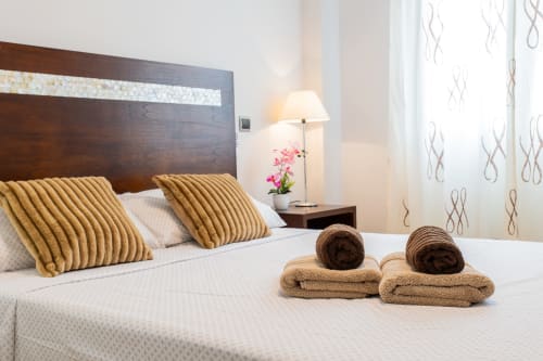Bedroom at Haus Holiday Homes in San Pedro del Pinatar with rolled towels, golden pillows, and modern furnishings