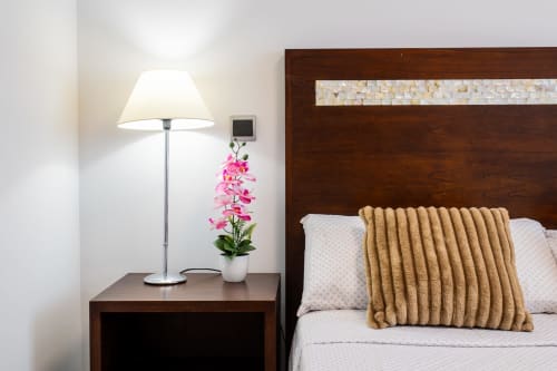 Bedroom nightstand with lamp and pink orchid at Haus Holiday Homes, San Pedro del Pinatar