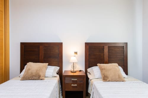 Two twin beds with dark wood headboards and beige pillows in Apto. Plus Ultra at Haus Holiday Homes, San Pedro del Pinatar