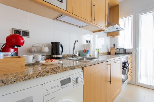 Modern kitchen in Apto. Plus Ultra apartment, San Pedro del Pinatar, with granite counters, wooden cabinets, and stainless