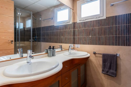 Modern bathroom with dual sinks, wood vanity, and dark tile accents at Haus Holiday Homes apartment in San Pedro del Pinatar
