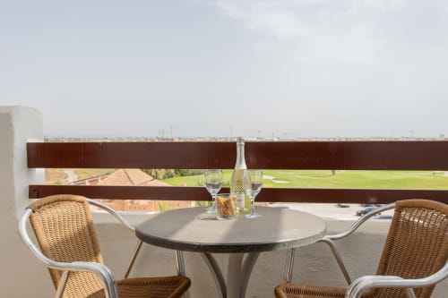Balcony seating area at Haus Holiday Homes in San Pedro del Pinatar with wicker chairs, round table, and sea view.