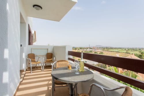 Balcony with wicker chairs, round table, and countryside views at Haus Holiday Homes in San Pedro del Pinatar