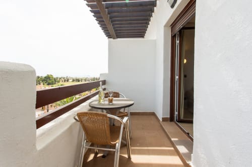 Private balcony at Haus Holiday Homes in San Pedro del Pinatar with wicker chair, round table, countryside views and pergola