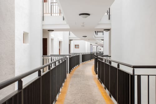Modern interior corridor at Haus Holiday Homes apartment in San Pedro del Pinatar with white walls, black railings, and