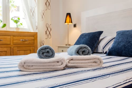 Rolled towels on striped bedding in Haus Holiday Homes Alfa Living apartment, San Pedro del Pinatar