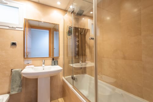 Modern bathroom in Alfa Living apartment at Haus Holiday Homes, San Pedro del Pinatar, with sink, mirror and glass-enclosed