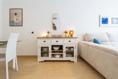 Bright living room in Haus Holiday Homes apartment with cream sofa, white storage cabinet, wooden floors, and modern décor in