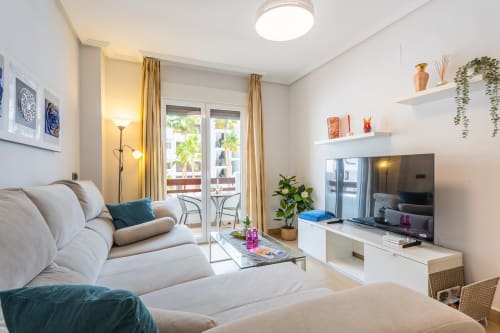 Modern living room in Alfa apartment at Haus Holiday Homes, San Pedro del Pinatar with comfortable seating, TV, balcony view