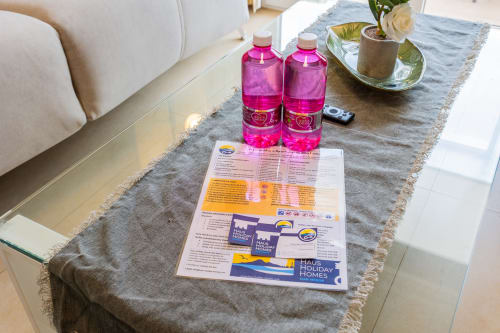 Welcome amenities at Haus Holiday Homes San Pedro del Pinatar: pink beverages, informational brochures, and fresh flowers on