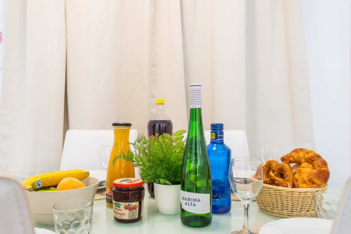 Welcome breakfast spread at Haus Holiday Homes featuring fresh fruit, juice, pastries, bread and Marina Alta wine in San