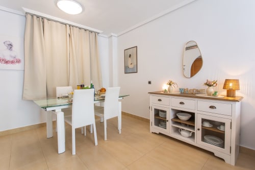 Modern dining room in Alfa Living apartment at Haus Holiday Homes, San Pedro del Pinatar with glass table, white chairs, and