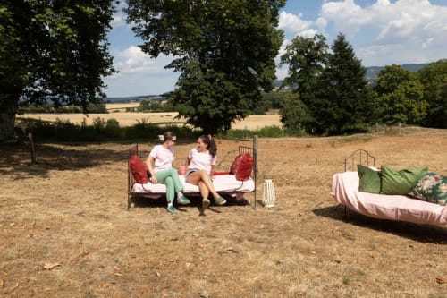Twee gasten ontspannen op vintage bedden in een veld bij Château de Vaux Morland, Étang sur Arroux, Frankrijk
