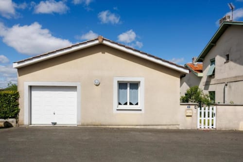 Façade du gîte Les Petits Toits, Libourne - maison d'hôtes couleur crème avec garage et accès jardin