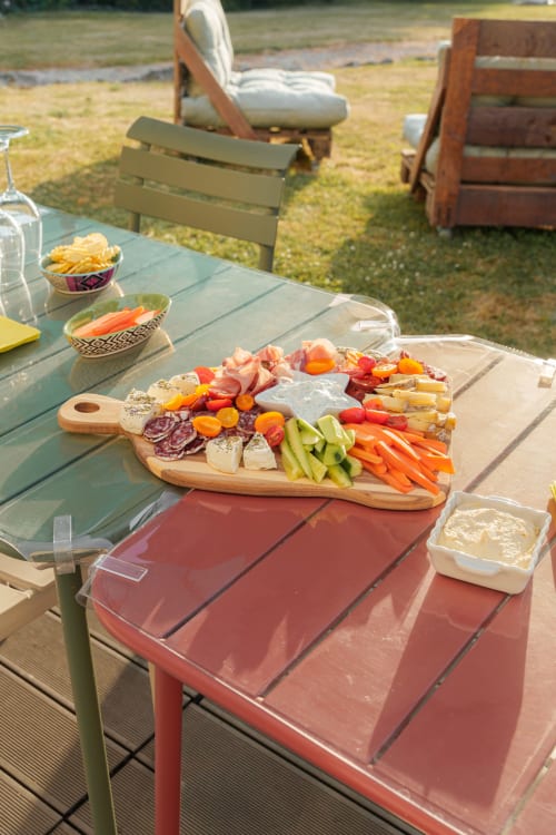 Outdoor picnic setup at Le Hameau de Céline with charcuterie board, fresh vegetables, and French countryside seating