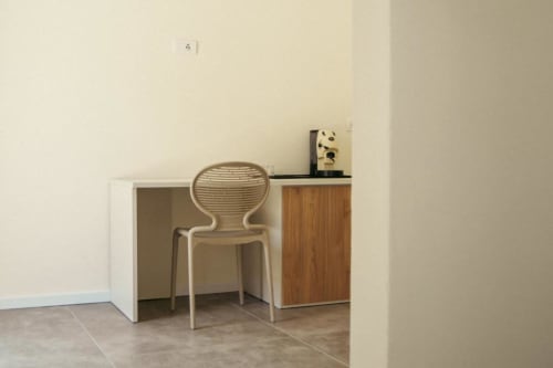 Scrivania moderna con sedia beige nella Sala Ulivo di villa Baglio Capo, Siculiana, con design minimalista dello spazio di lavoro