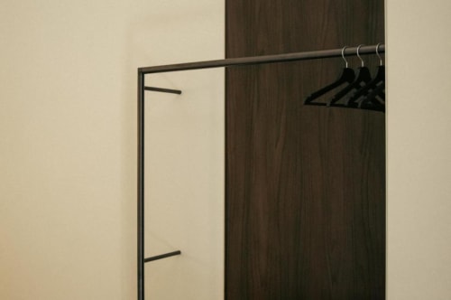 Guardaroba minimalista con grucce nere su asta nella suite Gelsomino di Baglio Capo, Siculiana