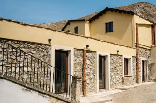 Camera dell'Ulivo nella villa Baglio Capo a Siculiana con terrazza in pietra, vista sul giardino e architettura tradizionale