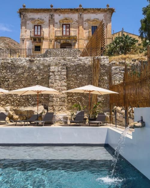 Piscina della Rosmarino Suite con acque turchesi affacciata sulla storica villa in pietra del Baglio Capo, Siculiana