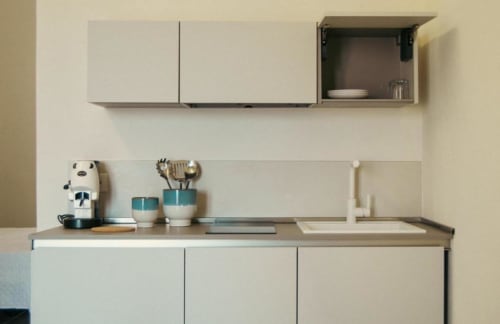 Piccola cucina moderna nella Rosmarino Suite di Baglio Capo: mobile bianco, elettrodomestici da banco e spazio portautensili