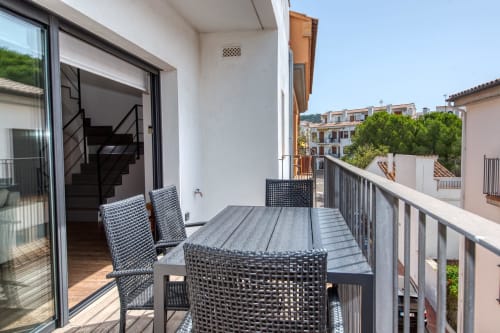 Balcony with dining table and chairs overlooking Calella de Palafrugell, modern duplex apartment with sea views