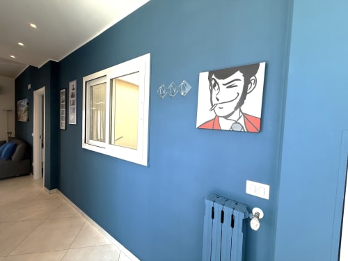Moderno corridoio blu nell'appartamento di Bari con opere d'arte cartoon e radiatore