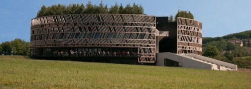 Modern curved architecture of Domaine de l'Ocrerie guesthouse nestled in Pourrain countryside with lush green fields
