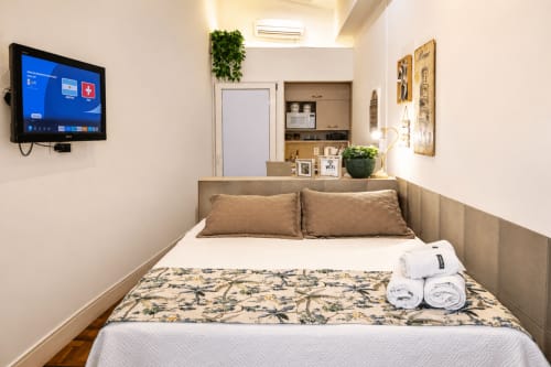 Quarto aconchegante Loft ROMA no CSS B&B em Maringá com cama, TV e vista para o jardim