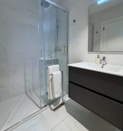 Salle de bain moderne au RIA CENTRUM Smart Residence à Aveiro avec douche à l'italienne, carrelage blanc marbré et vasque noire