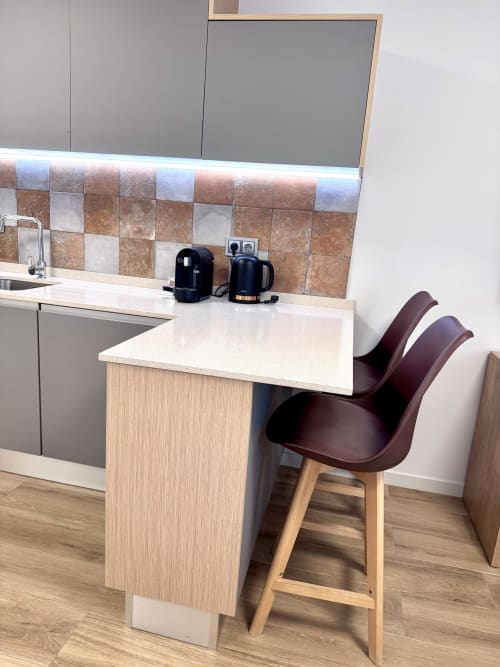 Cuisine moderne au RIA CENTRUM Estúdio Orange d'Aveiro, avec plan de travail blanc, crédence en carrelage marron et bar