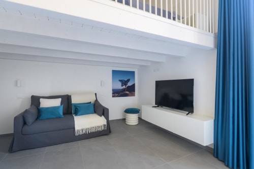 Appartamento Blu Ottanio dell'hotel Almatros a Sulmona con divano, TV e dettagli blu