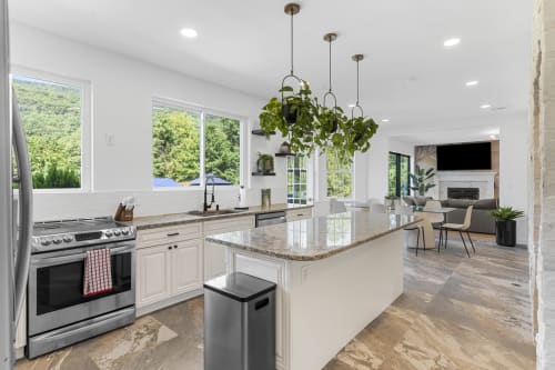 Modern kitchen with island, stainless steel appliances, and hanging plants in Malkita Terra villa, Woodbury