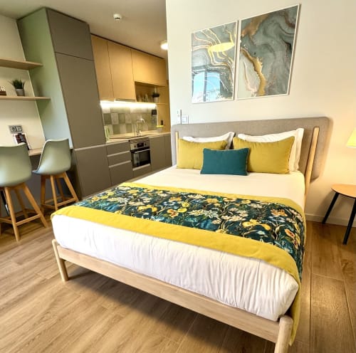 Estúdio Premium verde em RIA CENTRUM Aveiro com cama queen, detalhes amarelos, kitchenette e vista para o canal da varanda