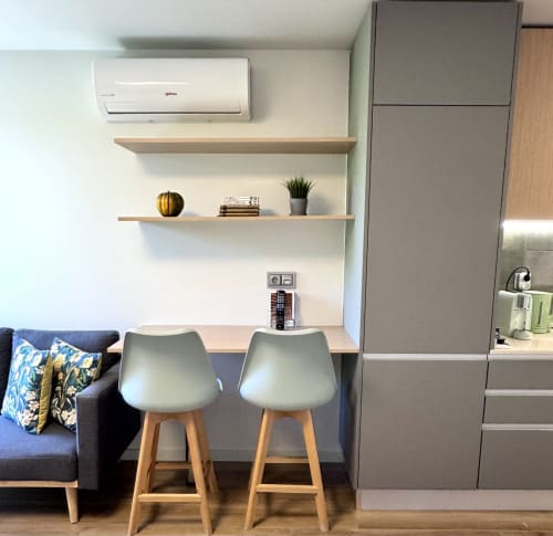 Espace de travail moderne au RIA CENTRUM avec bureau, tabourets hauts et étagères en bois dans un appartement à Aveiro