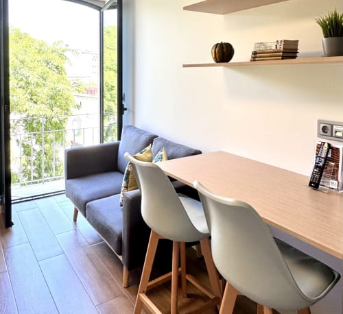 Séjour moderne au RIA CENTRUM à Aveiro avec espace de travail, canapé bleu, balcon avec vue sur la ville et étagères blanches