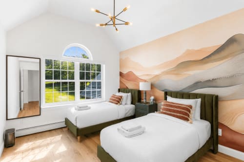 Mountain view bedroom at Malkita Terra villa in Woodbury with two beds, green headboards, landscape mural, and natural light.