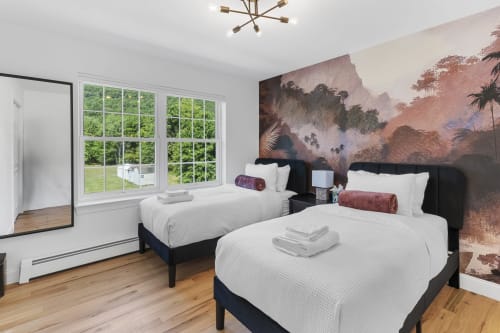 Two queen beds in Malkita Terra villa bedroom with mountain view mural, large windows overlooking greenery, wooden floors,