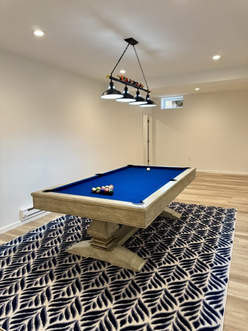 Billiard room in Malkita Terra villa at Malkita Homes, Woodbury with blue pool table, black pendant lighting, and patterned