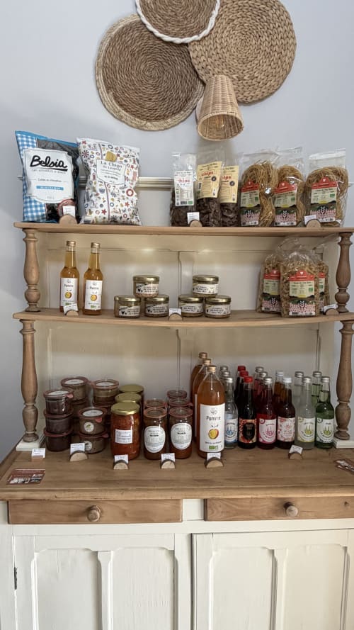 Étagère rustique en bois chez Le Hameau de Céline exposant les produits artisanaux locaux français, pots et bouteilles