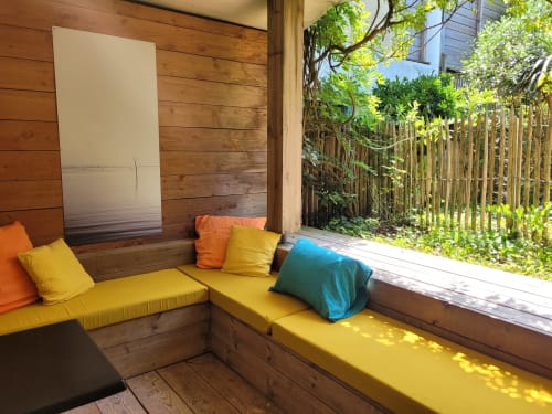 Sala giardino luminosa al Lodge du Cap Ferret con sedute gialle, cuscini colorati, pareti in legno e splendide vedute sul verde esterno