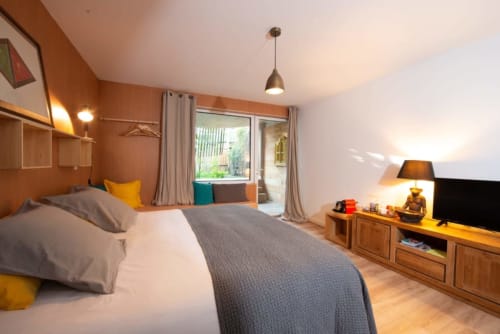 Camera spaziosa al Lodge du Cap Ferret con vista sul giardino, arredamento in legno e comfort moderni