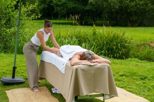 Thérapeute en massage effectuant un soin en plein air au Hameau de Céline B&B dans les Landes, France