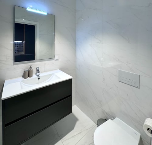 Salle de bain moderne dans l'appartement Premium Silver au RIA CENTRUM, Aveiro, carrelage marbre, vasque noire, miroir LED