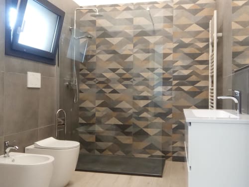 Bagno moderno nell'appartamento Amelia Blue di My Home Apulia con doccia con piastrelle geometriche, toilette, bidet e lavabo con vanity bianco