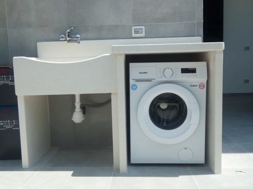 Lavanderia con lavabo integrato e lavatrice Comfee nell'appartamento Amelia Blue di My Home Apulia, Veglie