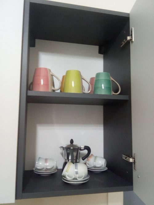 Mensola nera nella suite Amelia Blue con coloratissime tazze e servizio da caffè presso My Home Apulia, Veglie