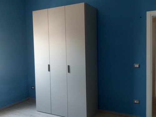 Guardaroba bianco moderno nell'appartamento Amelia Blue di My Home Apulia a Veglie, con pareti blu e pavimento in piastrelle
