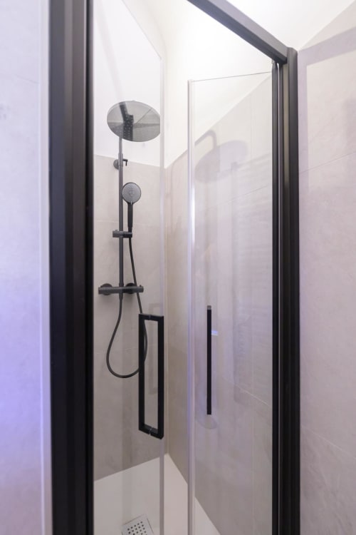 Moderna doccia nera con soffione e doccetta manuale nelle Rubino Design Suites dell'hotel Almatros di Sulmona