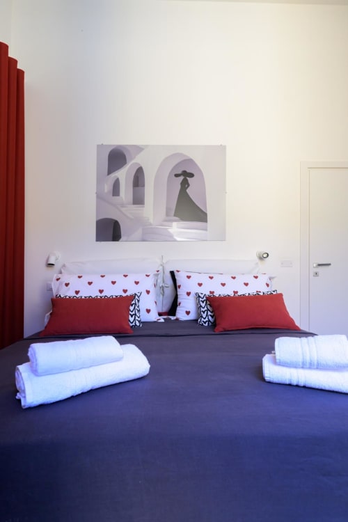 Suite Rubino Design presso l'hotel Almatros di Sulmona con biancheria a cuori, cuscini rossi e asciugamani arrotolati