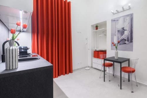Suites Design Rubino ad Almatros Sulmona: appartamento moderno con tende rosse, scrivania nera, pareti bianche e design contemporaneo